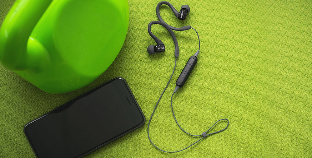 BT232i FitClips Wireless Bluetooth® Ear Clip Headphones on a green background.