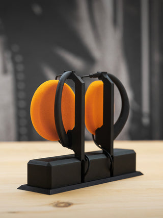 Black stand with orange objects on a wooden surface