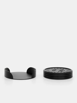 Black coaster set with a round holder on a white background