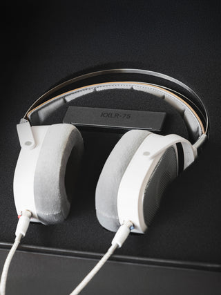 White headphones with a visible brand logo on a black background