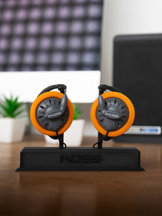 Koss headphones on a stand with a blurred office background