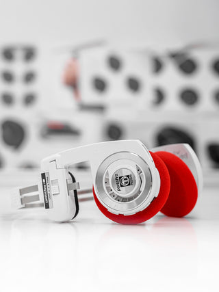 White Porta Pro with red cushions on a white background with blurred patterned fabric in the background