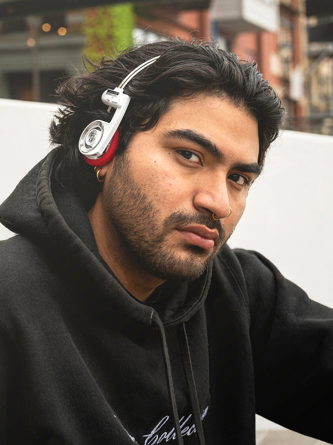 Man wearing headphones with a blurred urban background