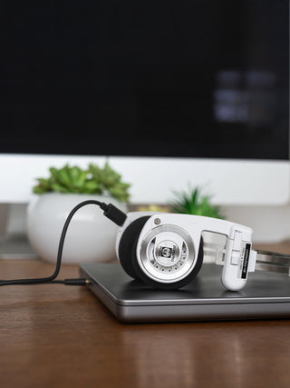 White headphones with a USB cable on a laptop screen
