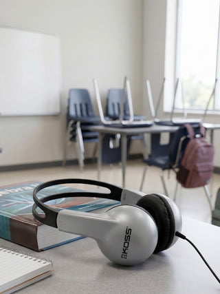 Koss headphones on a desk in a classroom setting