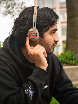 Man using the integrated audio controls on KPH30 Wireless sitting outdoors.