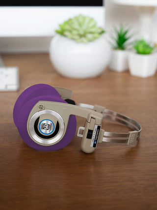 Koss Porta Pro Wireless Rhythm Beige laying on a desk with Purple Oversized Cushions