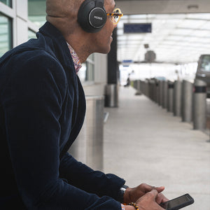 Man waiting at drop-off zone wearing Koss BT740i QZ  Headphones